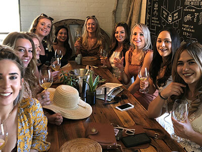 a bunch of lady tourist having so much fun while enjoying the place and the taste of their wine in their pokolbin wine tours